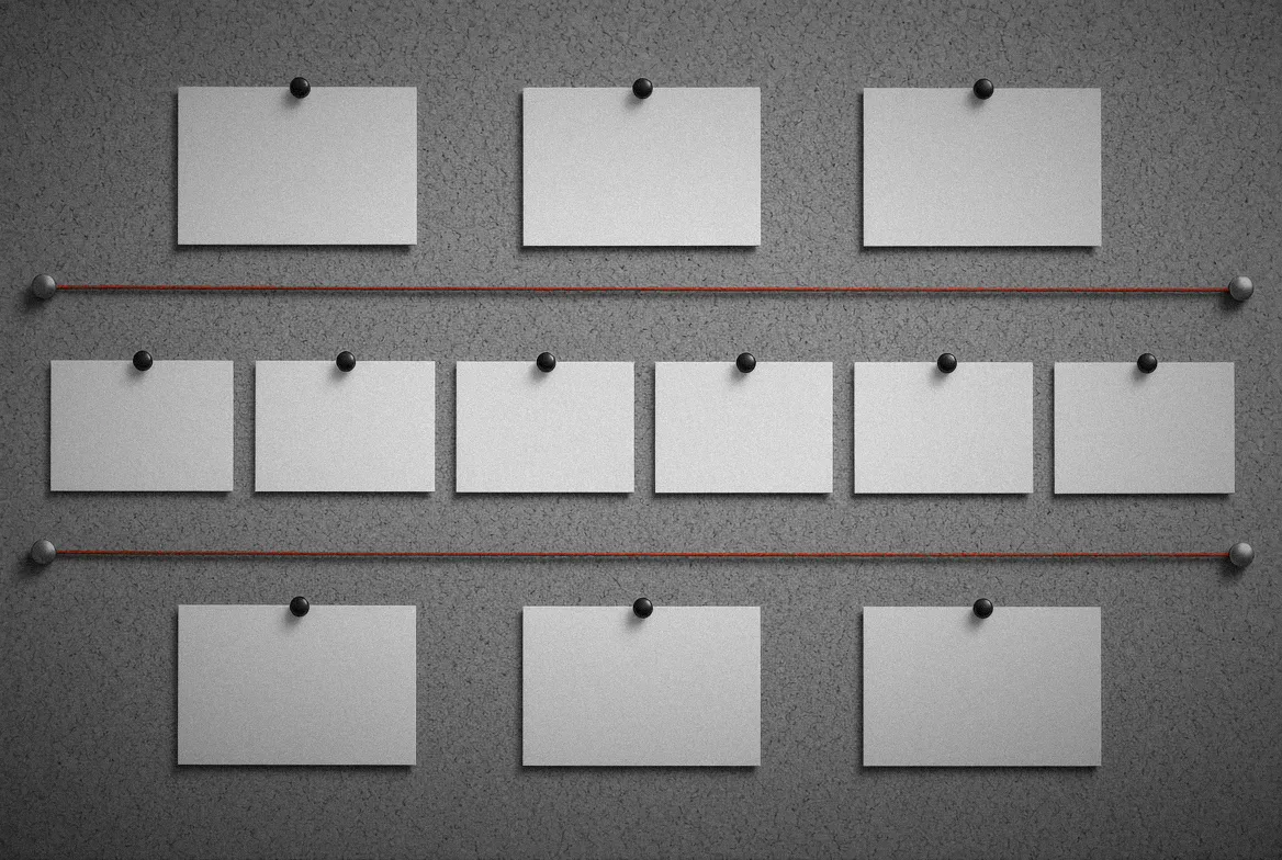 Un corcho con doce tarjetas blancas en blanco repartidas en tres filas, tres arriba, seis en medio y tres abajo, separadas por dos hilos rojos tensados de lado a lado.